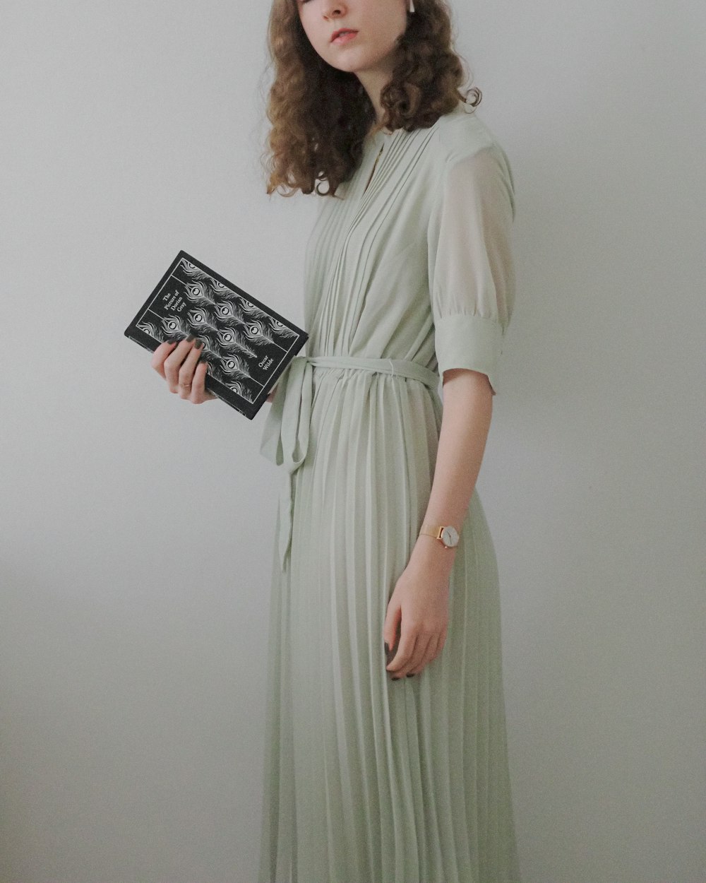 a woman in a green dress holding a black box