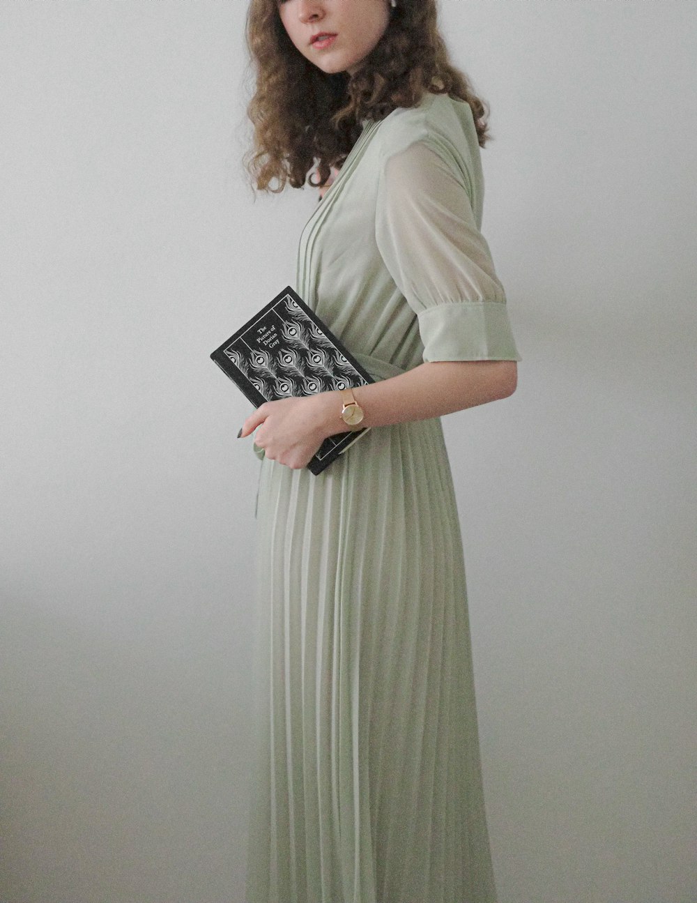 a woman in a green dress holding a black purse