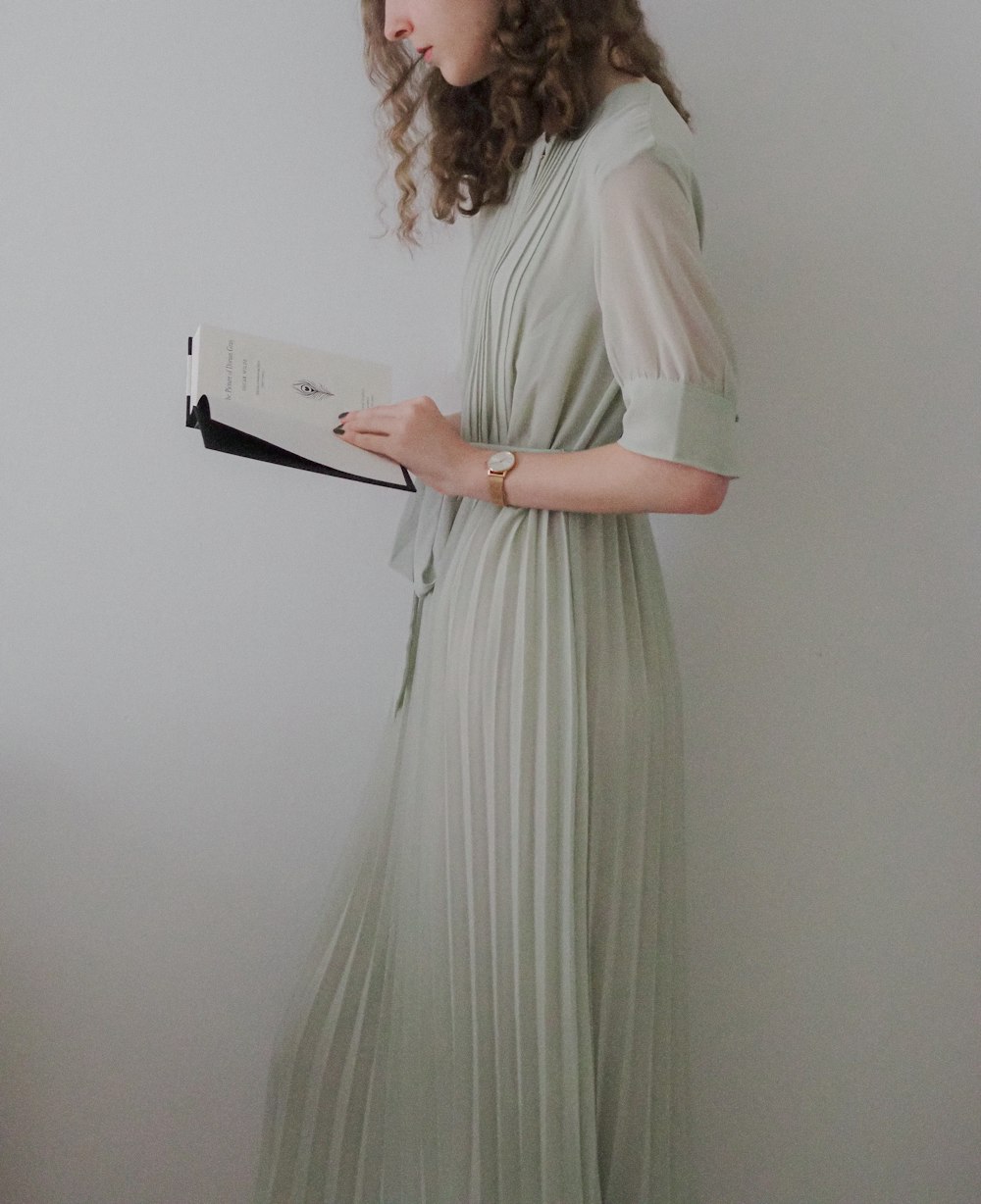 a woman in a dress reading a book