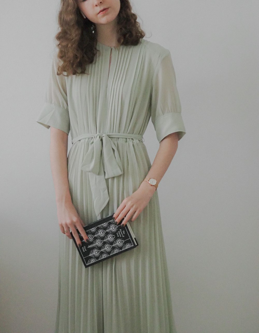 a woman in a green dress holding a black purse