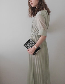 a woman in a long dress holding a book