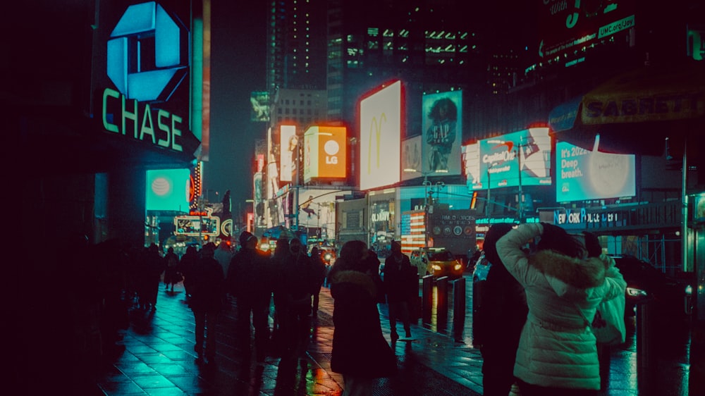 a group of people walking down a street at night