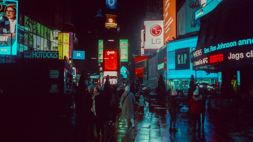 a group of people walking down a street at night