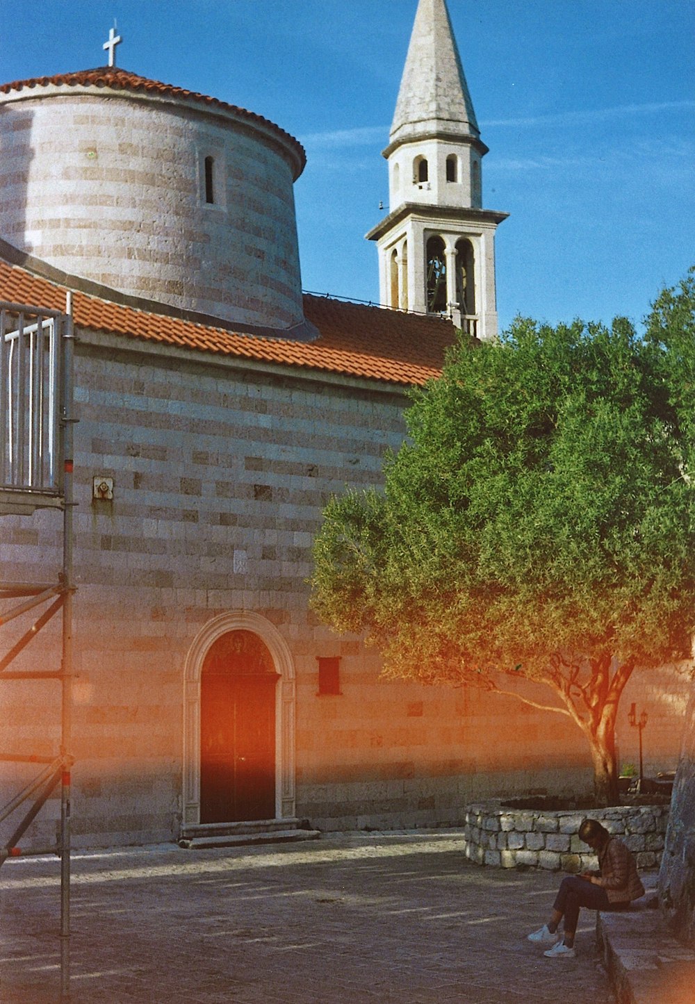 a person sitting on a bench in front of a building