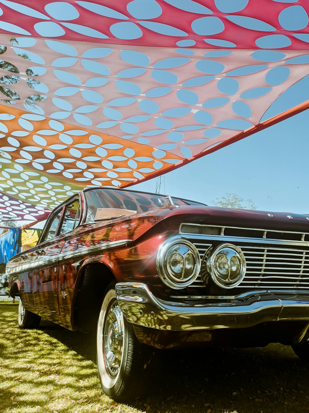 an old car is parked under a canopy