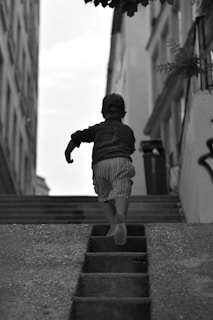 a little boy that is walking down some stairs