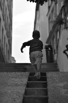 a little boy that is walking down some stairs
