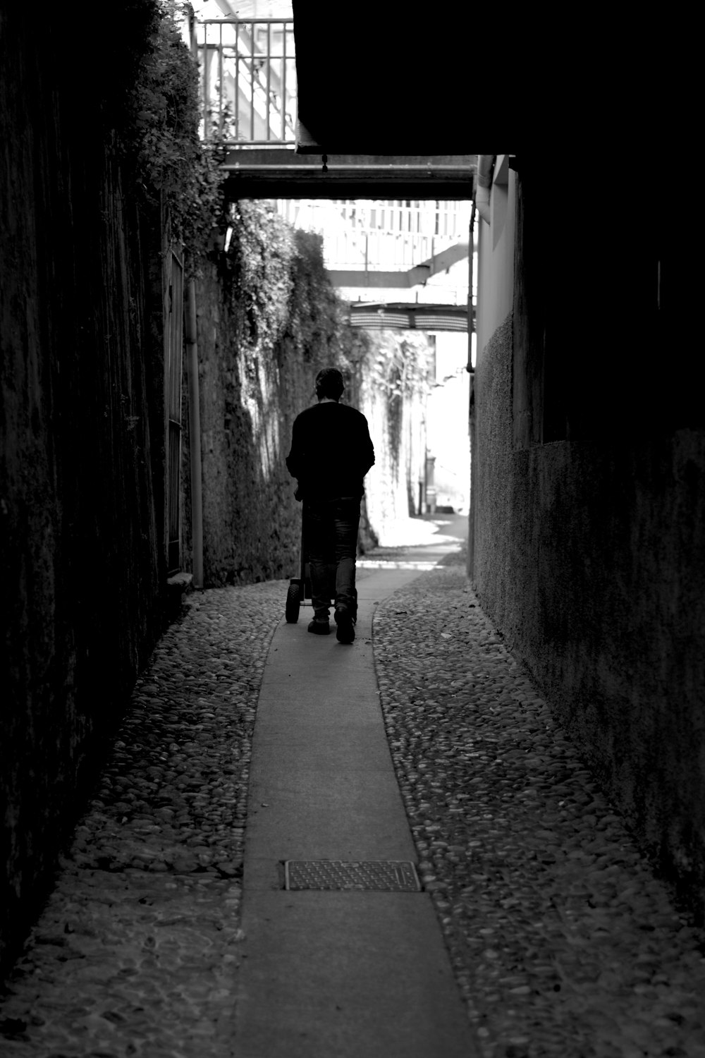 a man walking down a narrow alley way