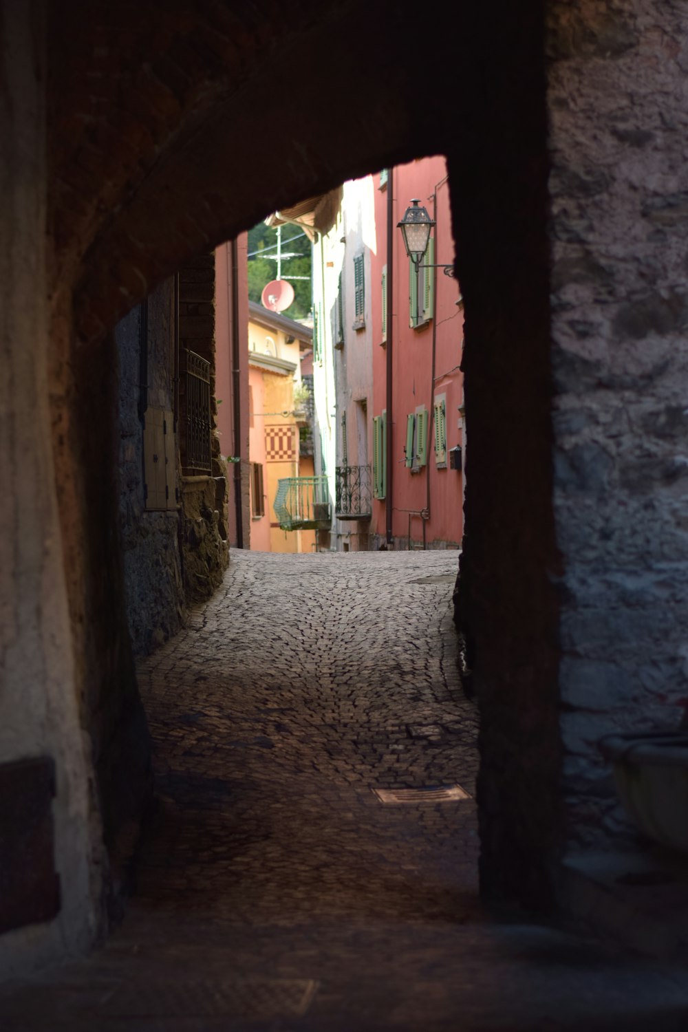 a narrow alley way with a clock on the wall