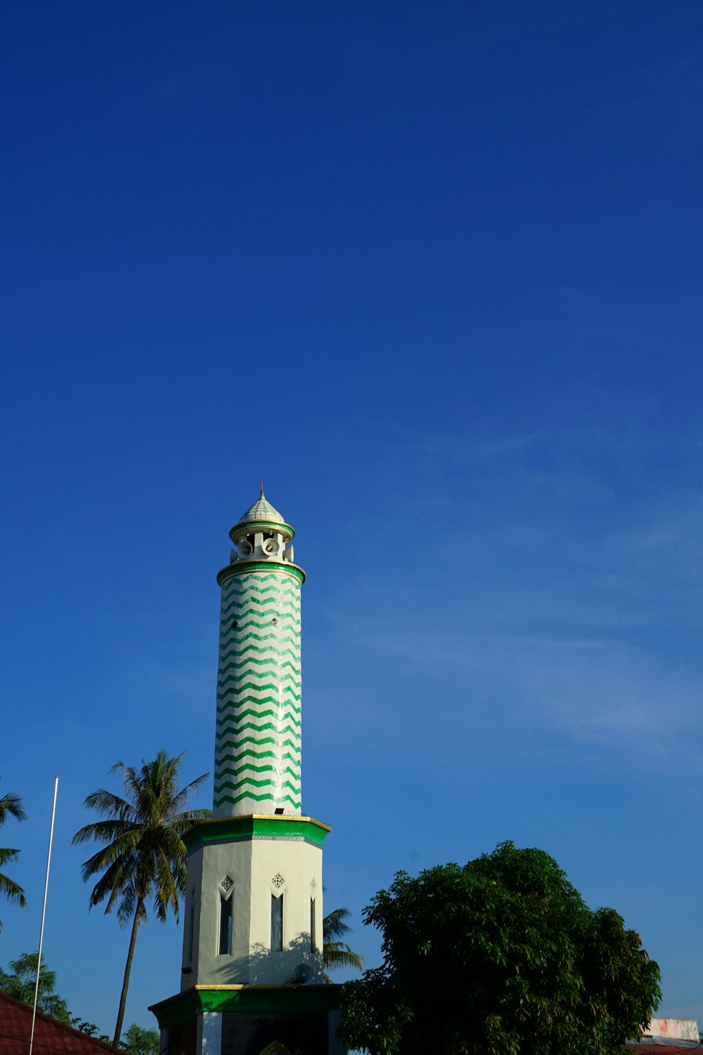 a white and green tower with a clock on top