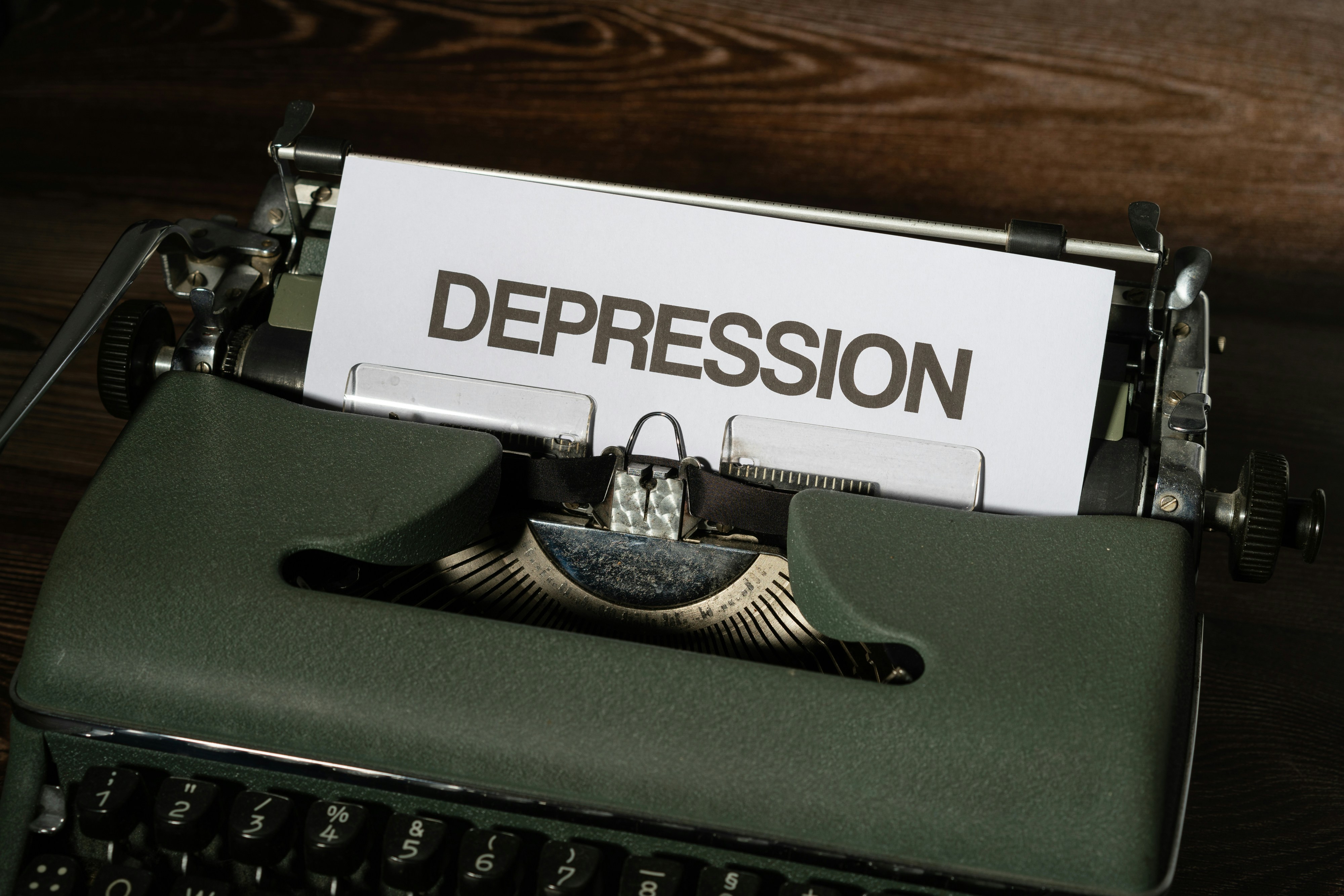 a close up of a typewriter with a paper that reads depression