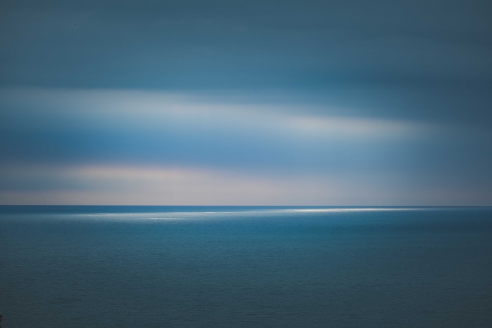 a large body of water under a cloudy sky