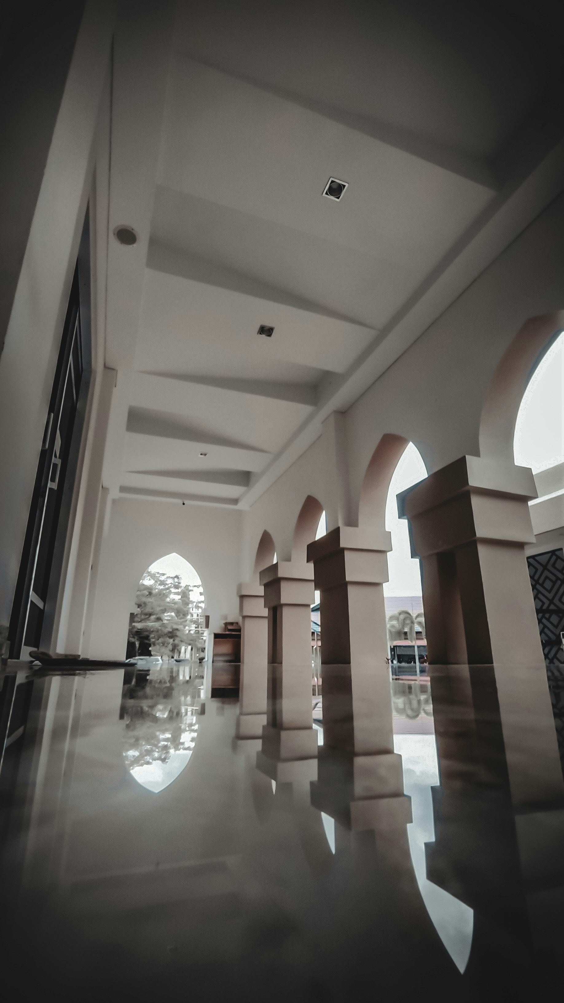 a large room with columns and a clock on the wall