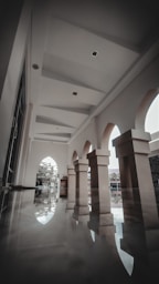 a large room with columns and a clock on the wall