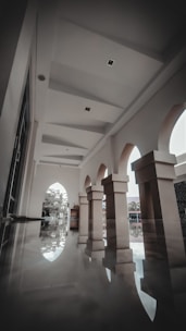a large room with columns and a clock on the wall