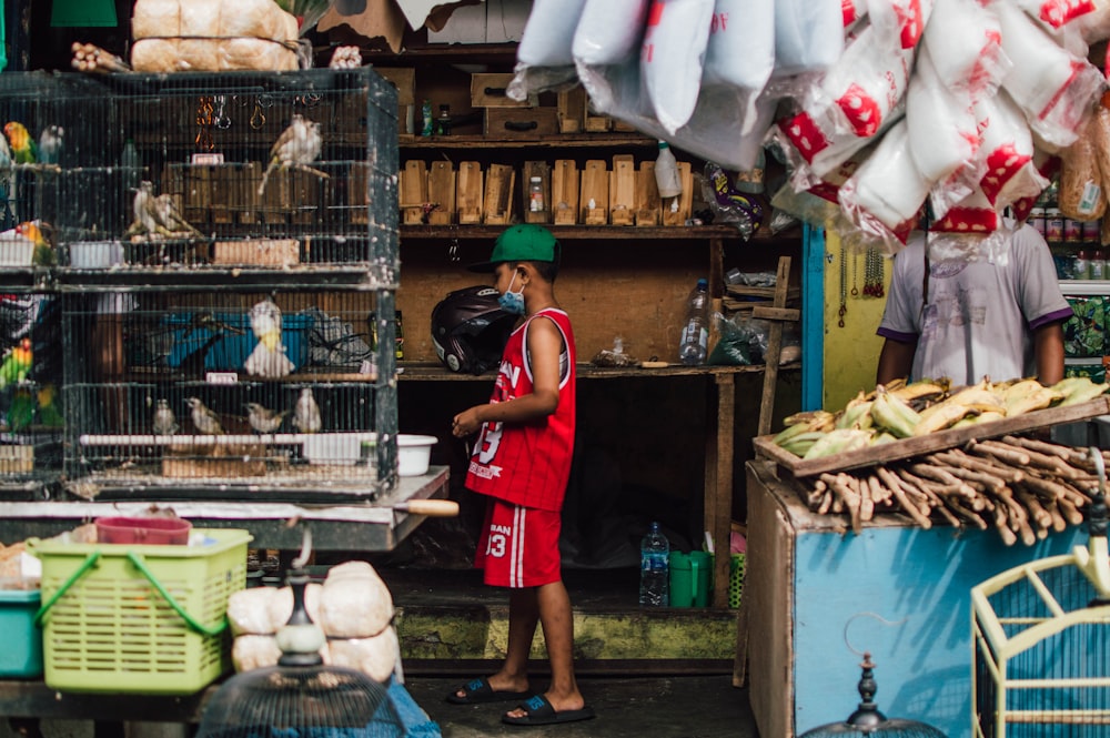 a man standing in front of a bird cage