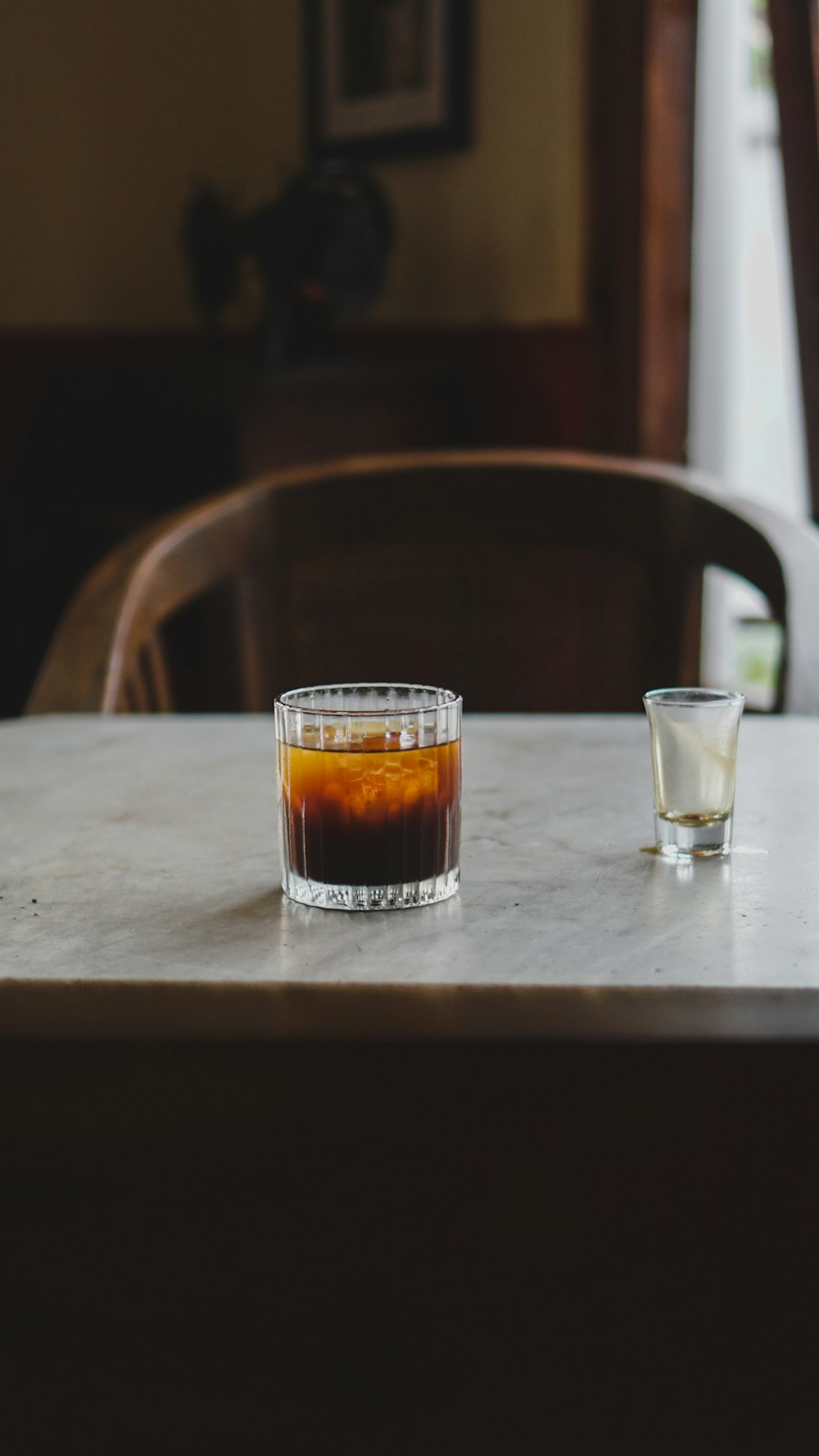 a glass of liquid sitting on top of a table