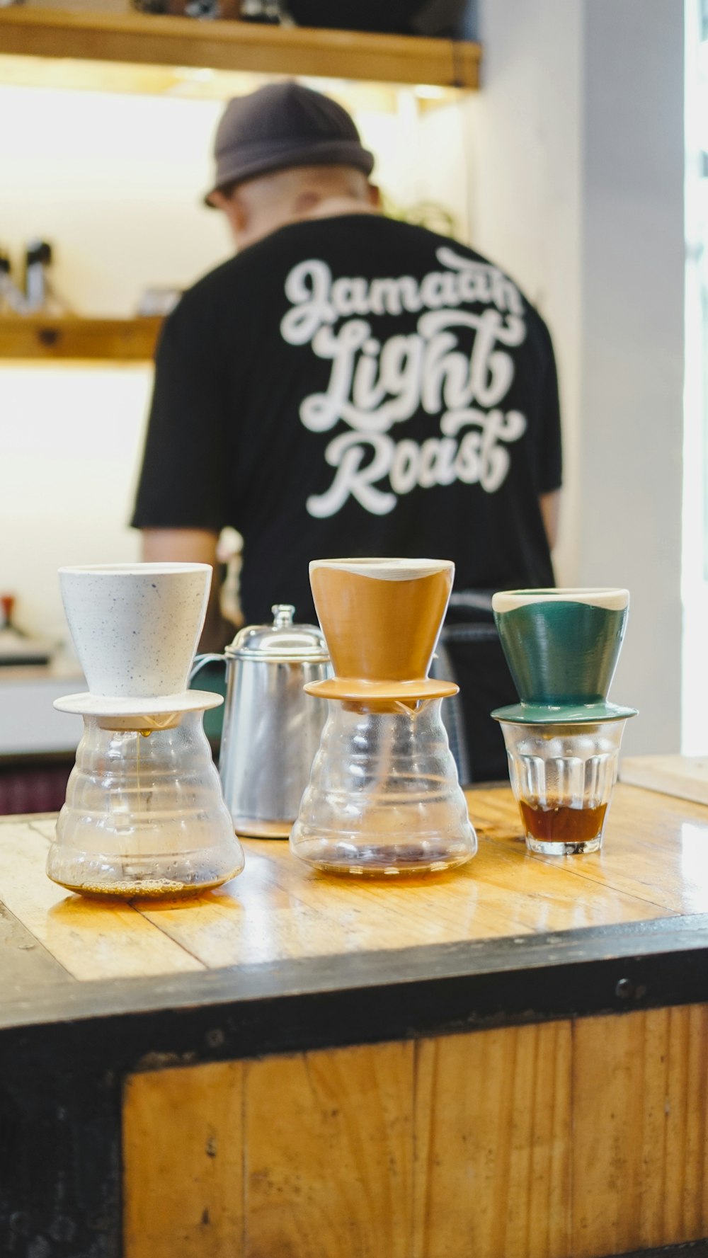 a man standing behind a counter with cups on it