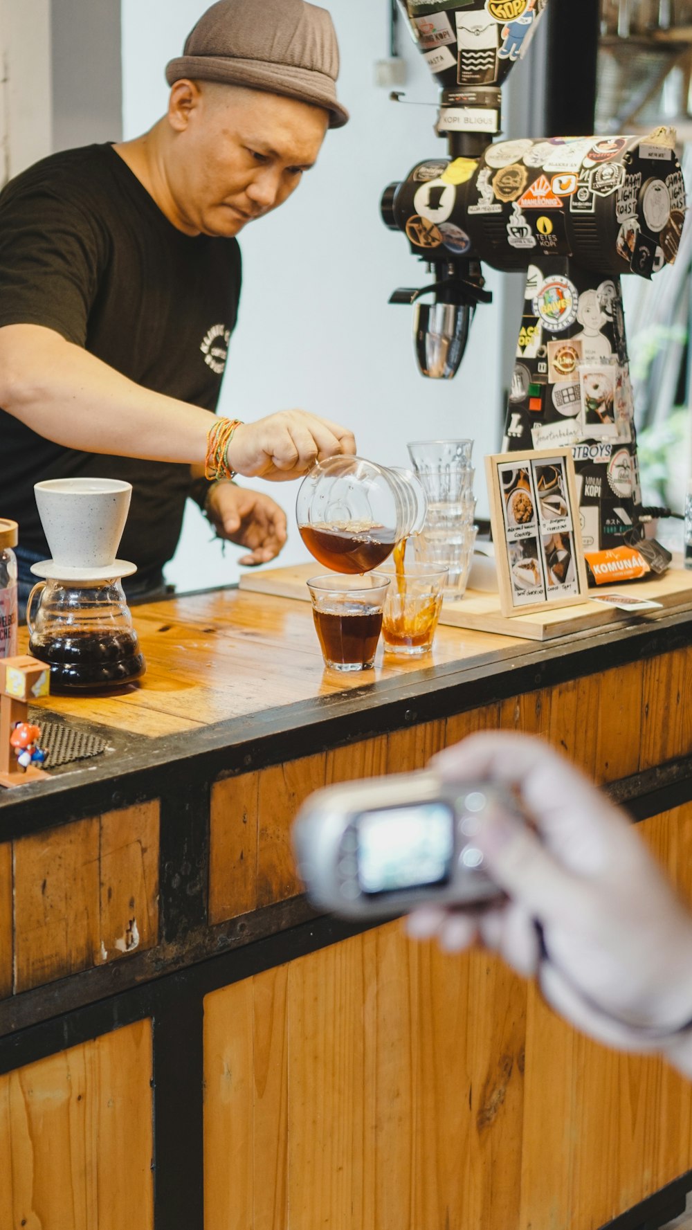 a man standing at a counter making a drink