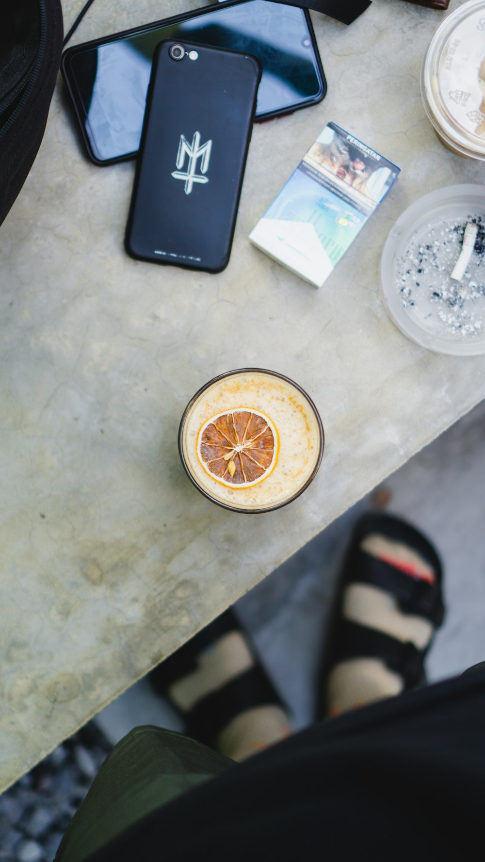 a table topped with a phone and a bowl of fruit