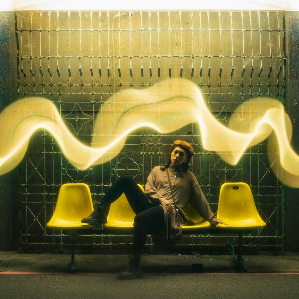 a man sitting on a bench in front of a wall