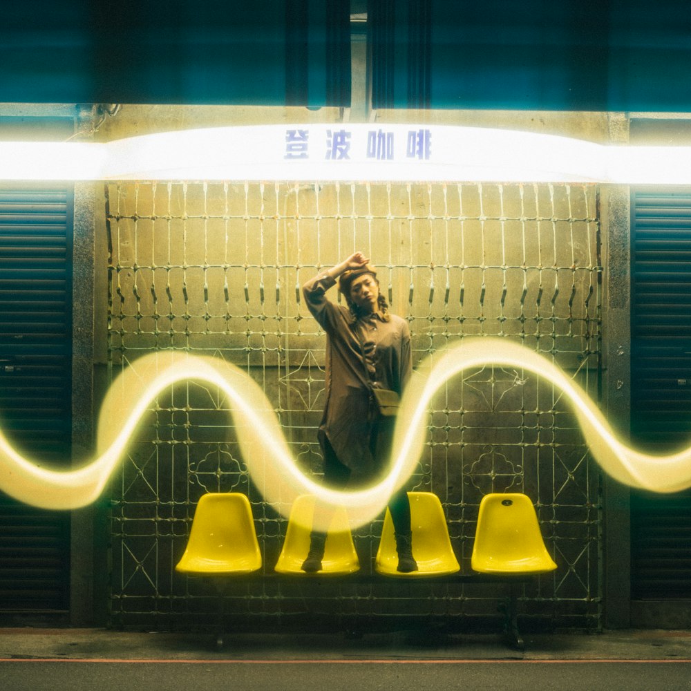 a man standing in front of a yellow wall