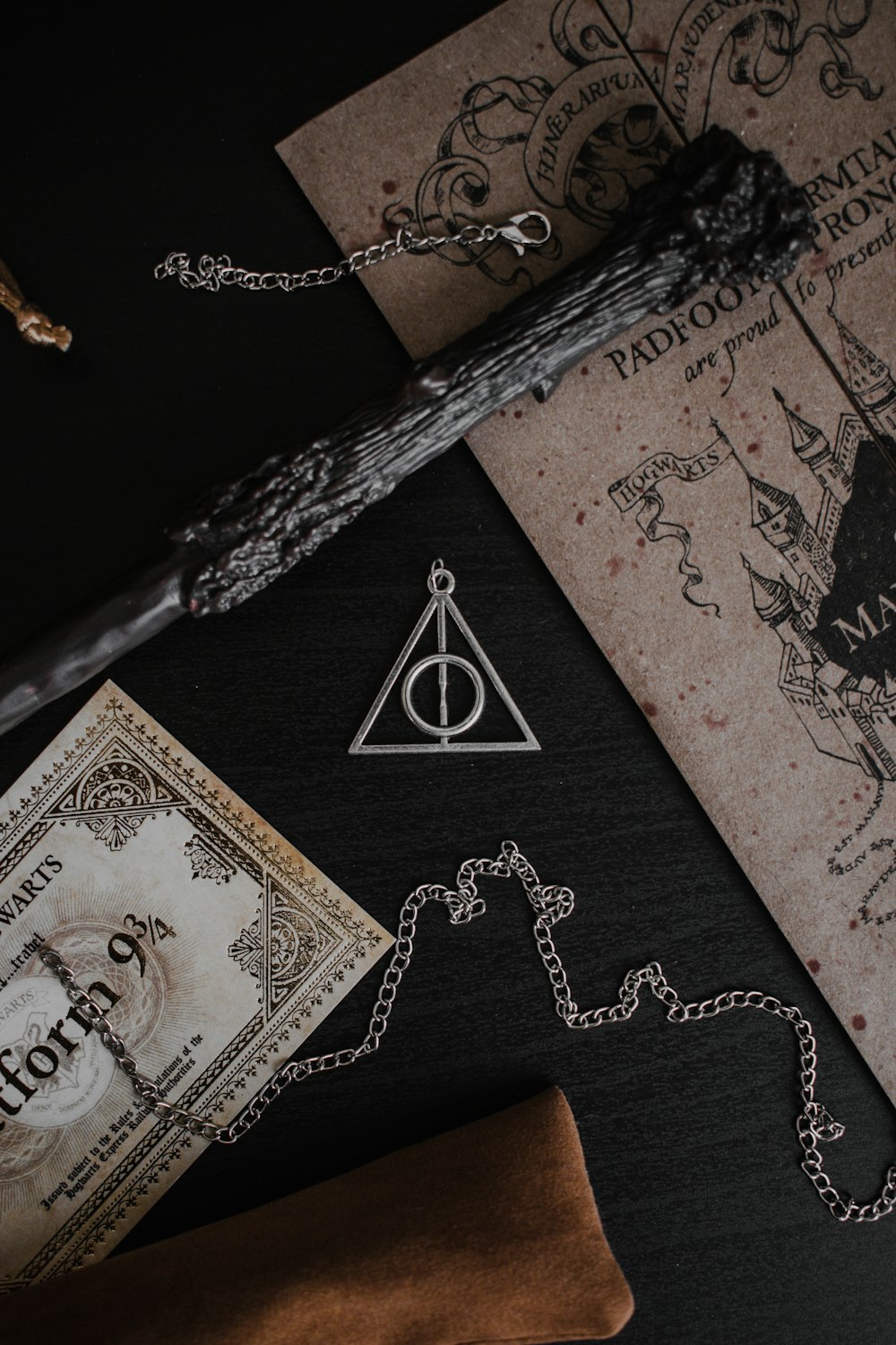 a harry potter necklace next to a money bill