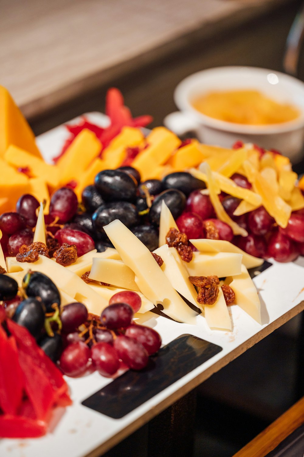 a plate of cheese and grapes on a table