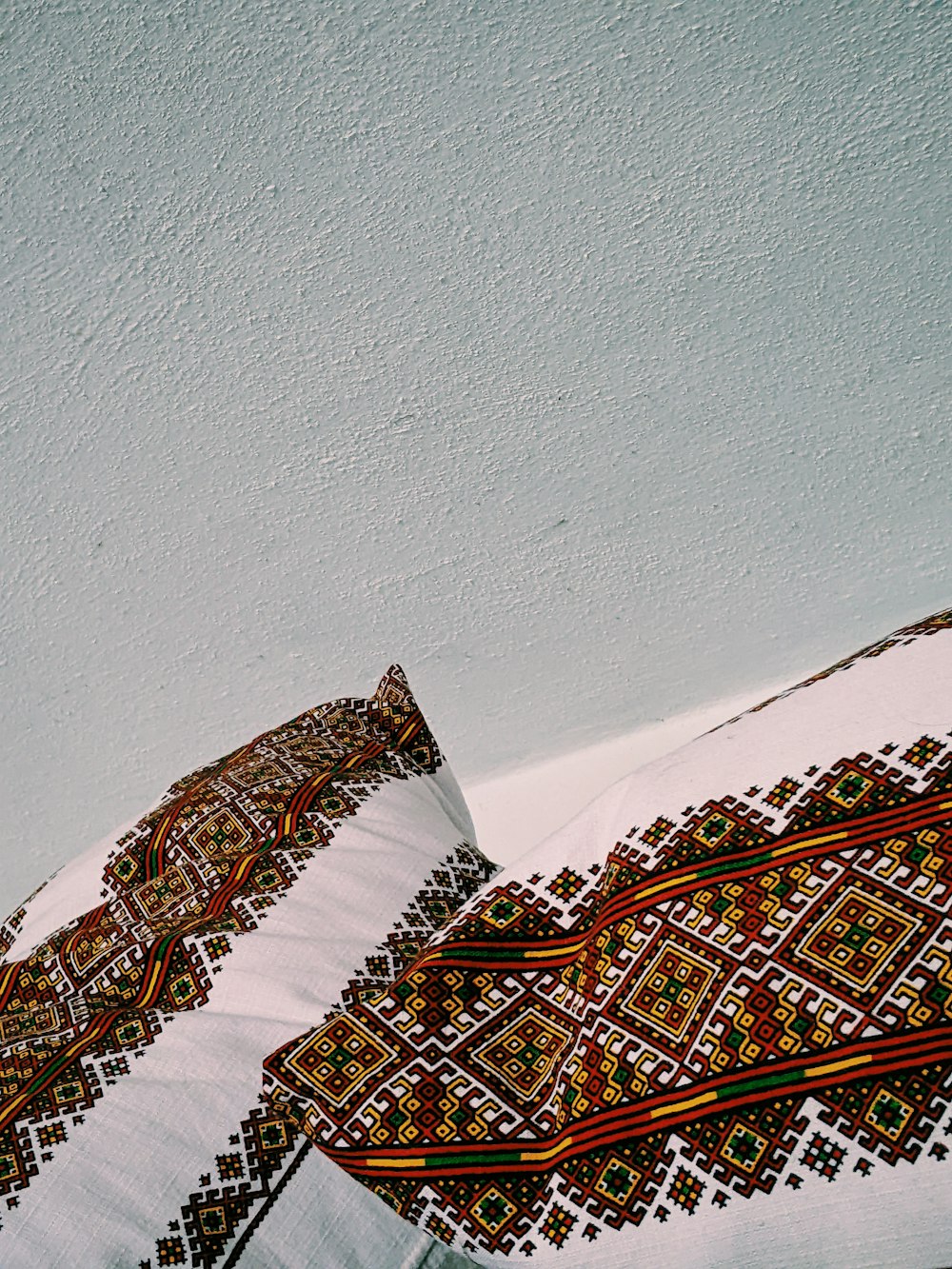 a close up of two pillows on a bed