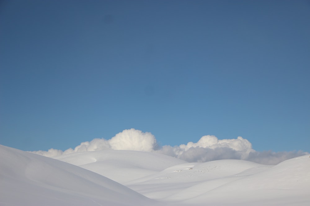 uma pessoa que monta esquis em cima de uma encosta coberta de neve