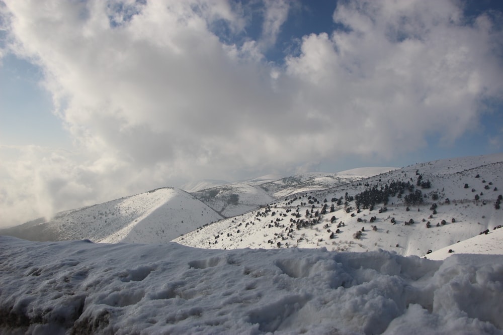 une vue d’une montagne enneigée avec des nuages dans le ciel