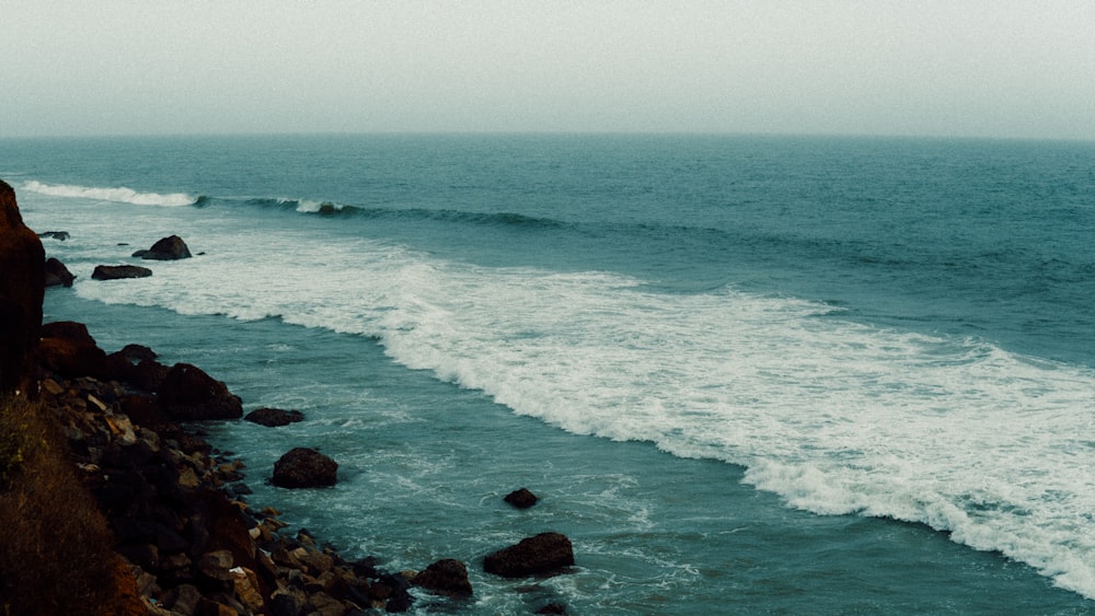 a person standing on the edge of a cliff overlooking the ocean