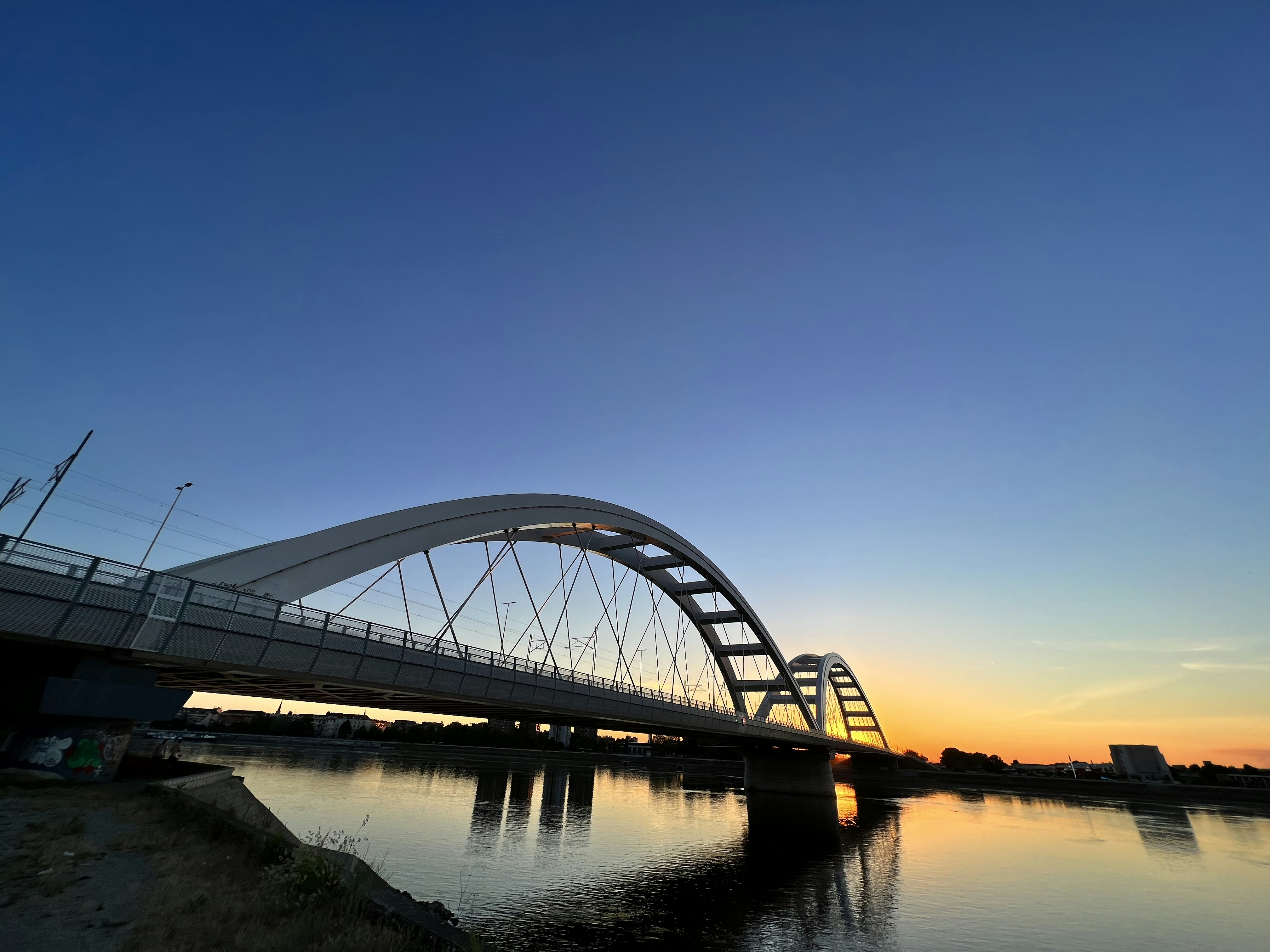 a bridge over a body of water at sunset