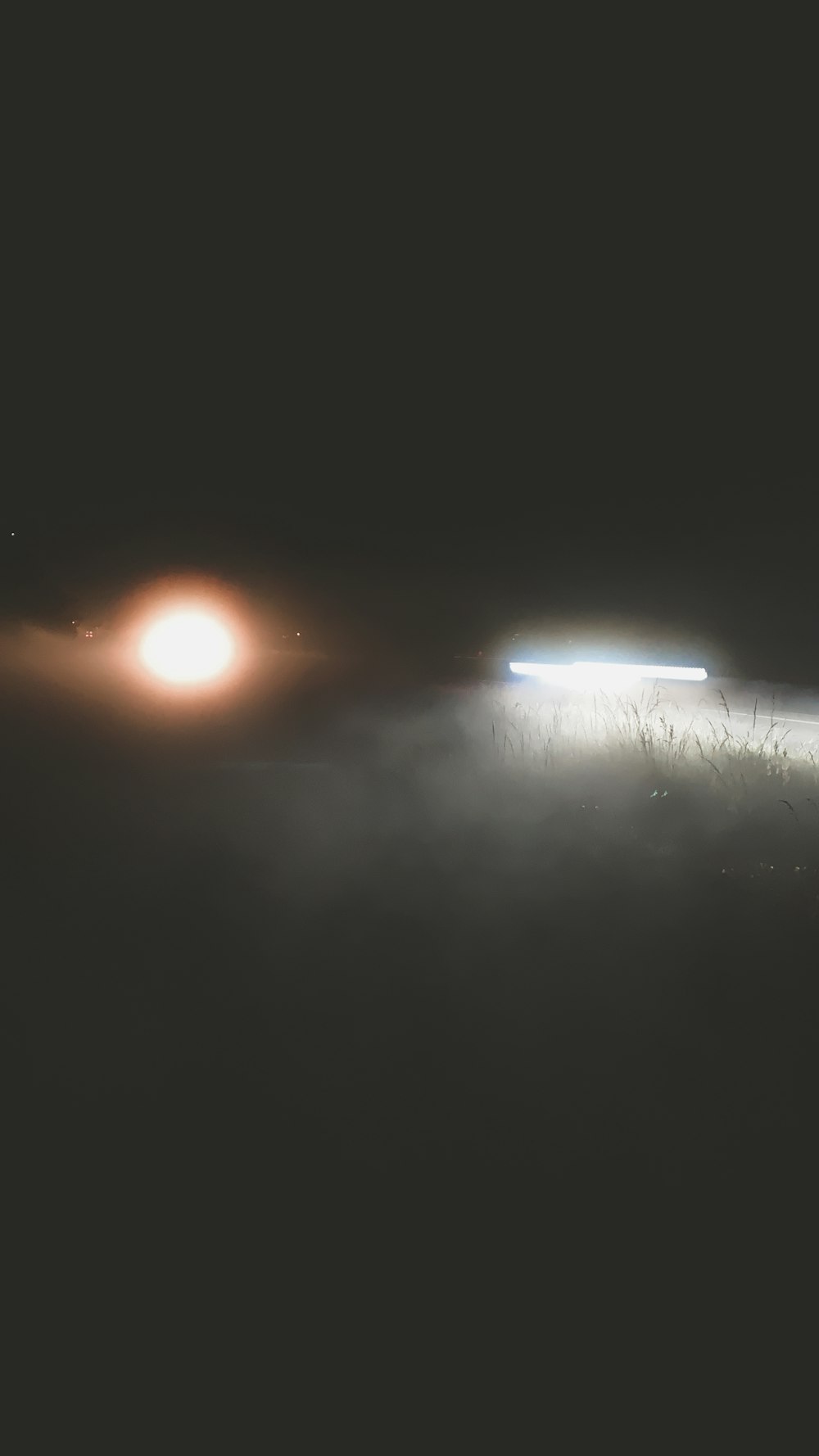 a car driving down a foggy road at night