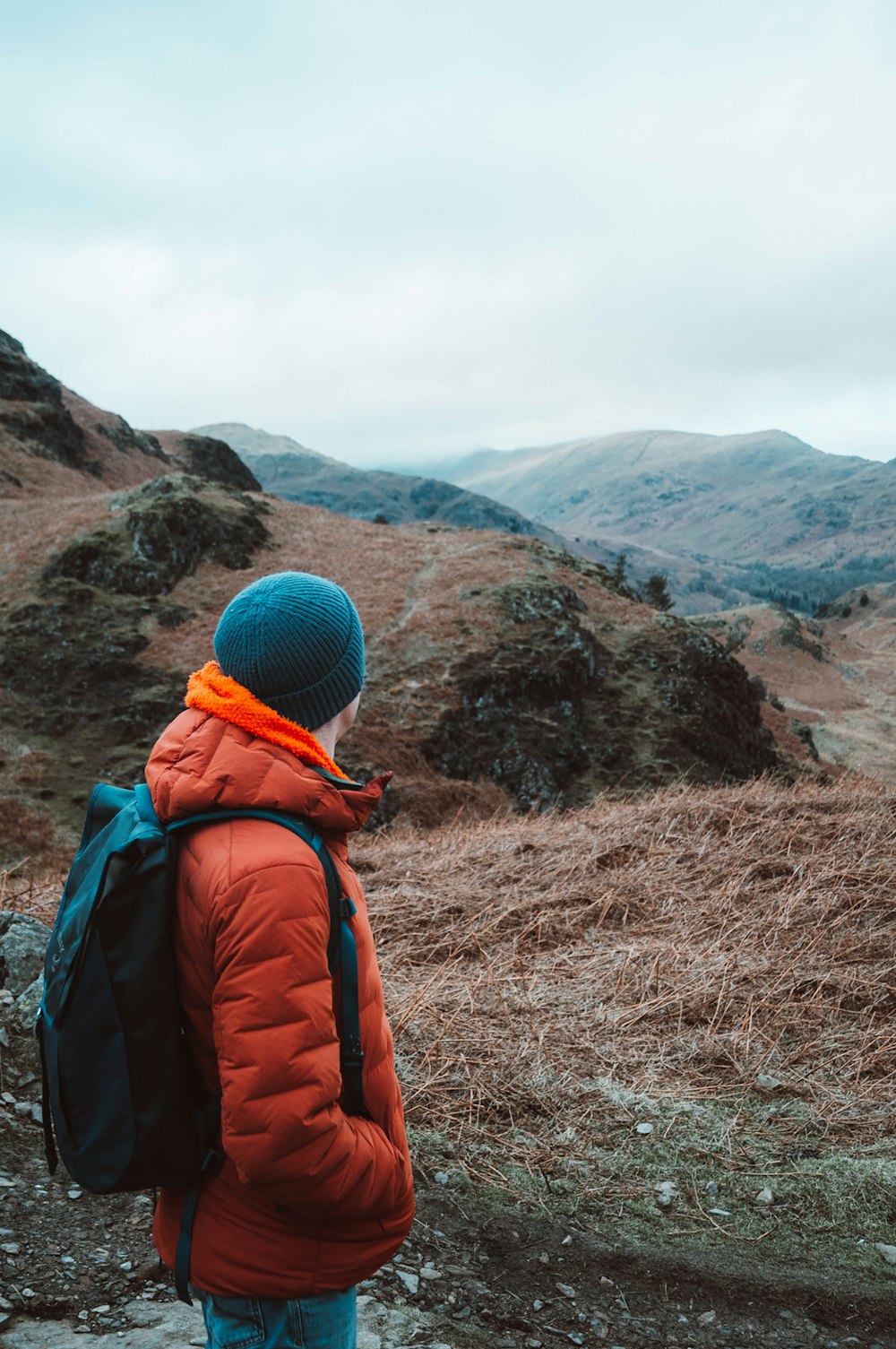 Eine Person mit einem Rucksack schaut auf die Berge