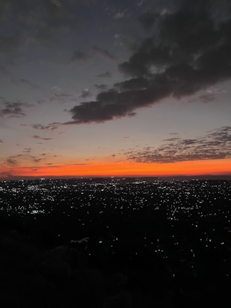 A minimalist cityscape with warm orange lights glowing at dusk.