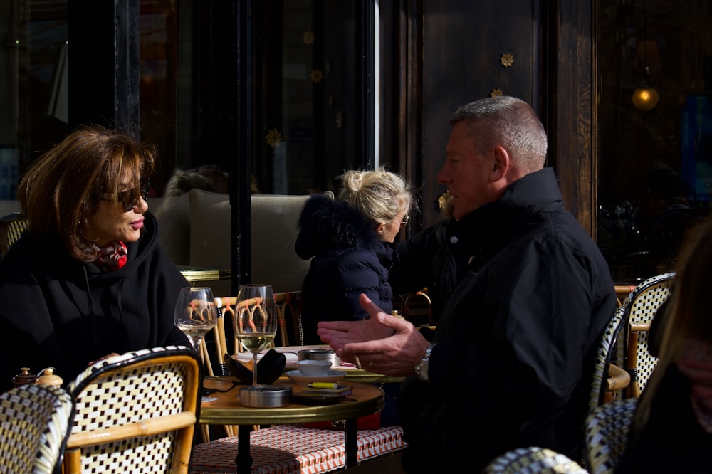 un groupe de personnes assises à une table à l’extérieur