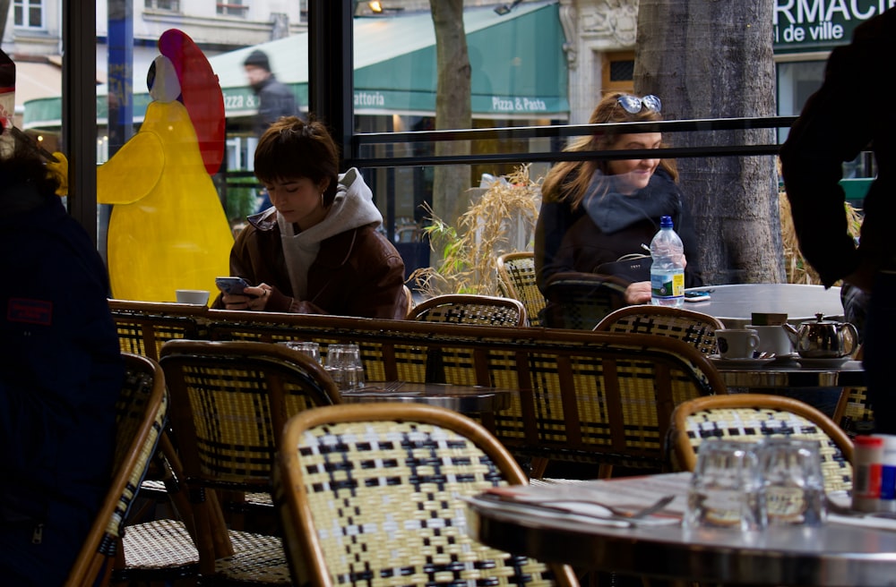 a group of people sitting at tables in a restaurant