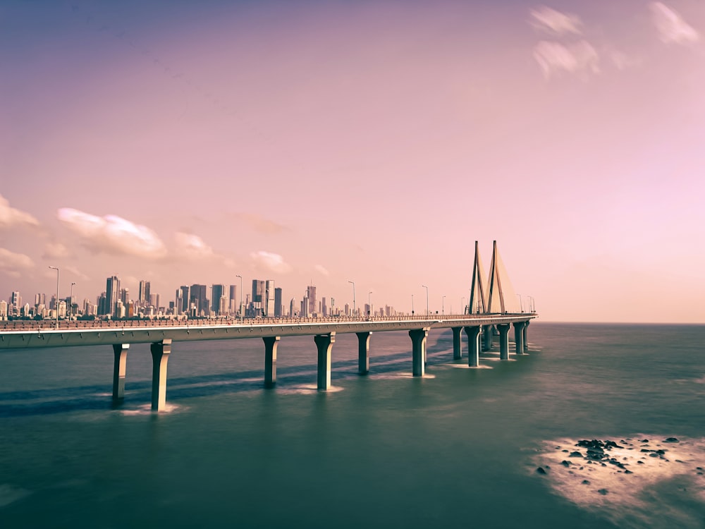 a long bridge over a body of water with a city in the background