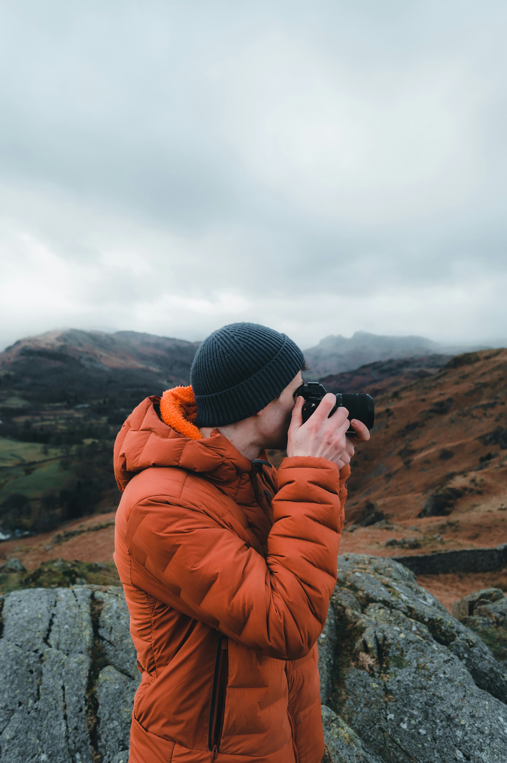 A man takes a photo on the Lake District fells.