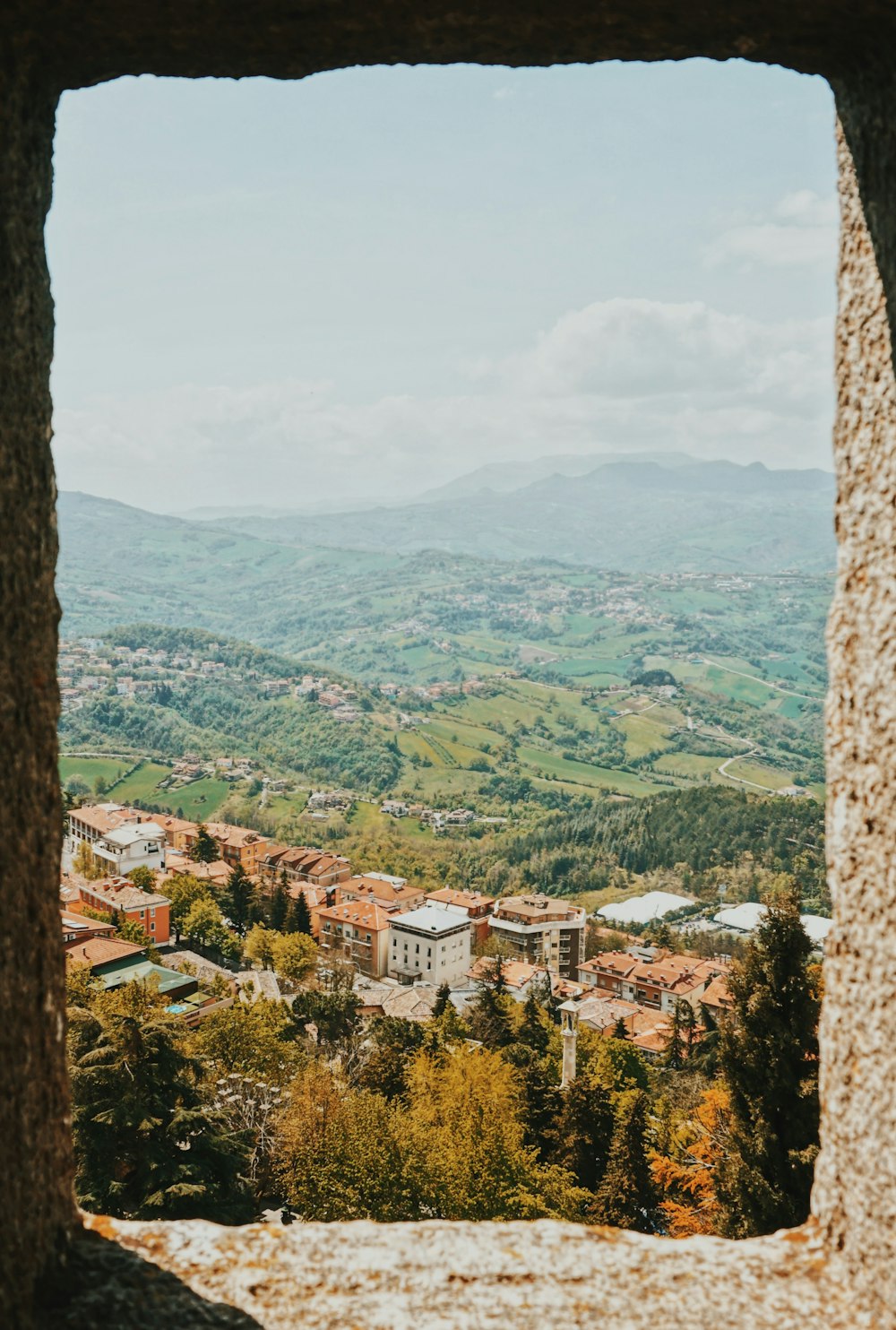 a view of a town from a window in a stone wall