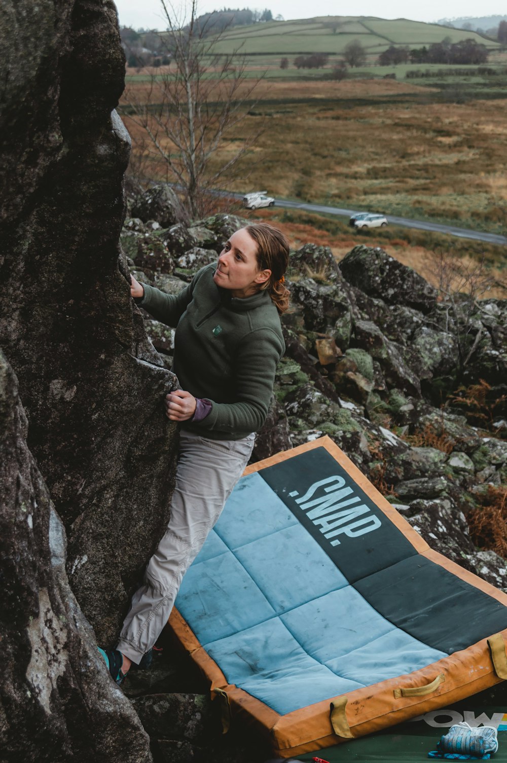 a woman climbing up the side of a mountain