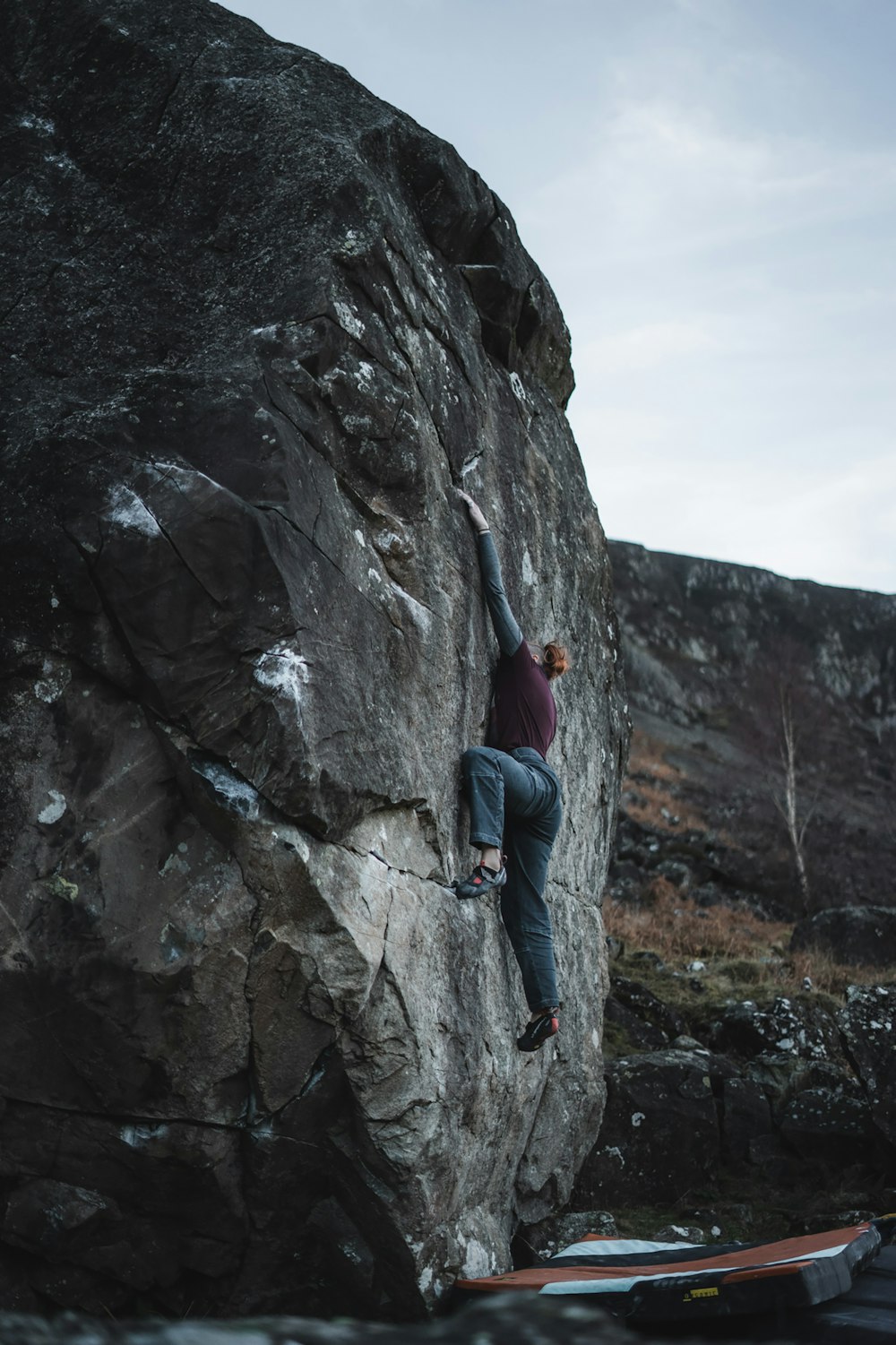 a man standing in front of a large rock