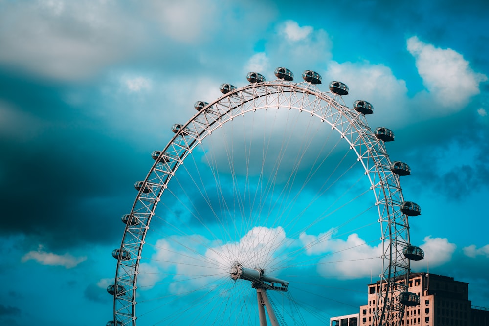 Una grande ruota panoramica seduta accanto a un edificio alto