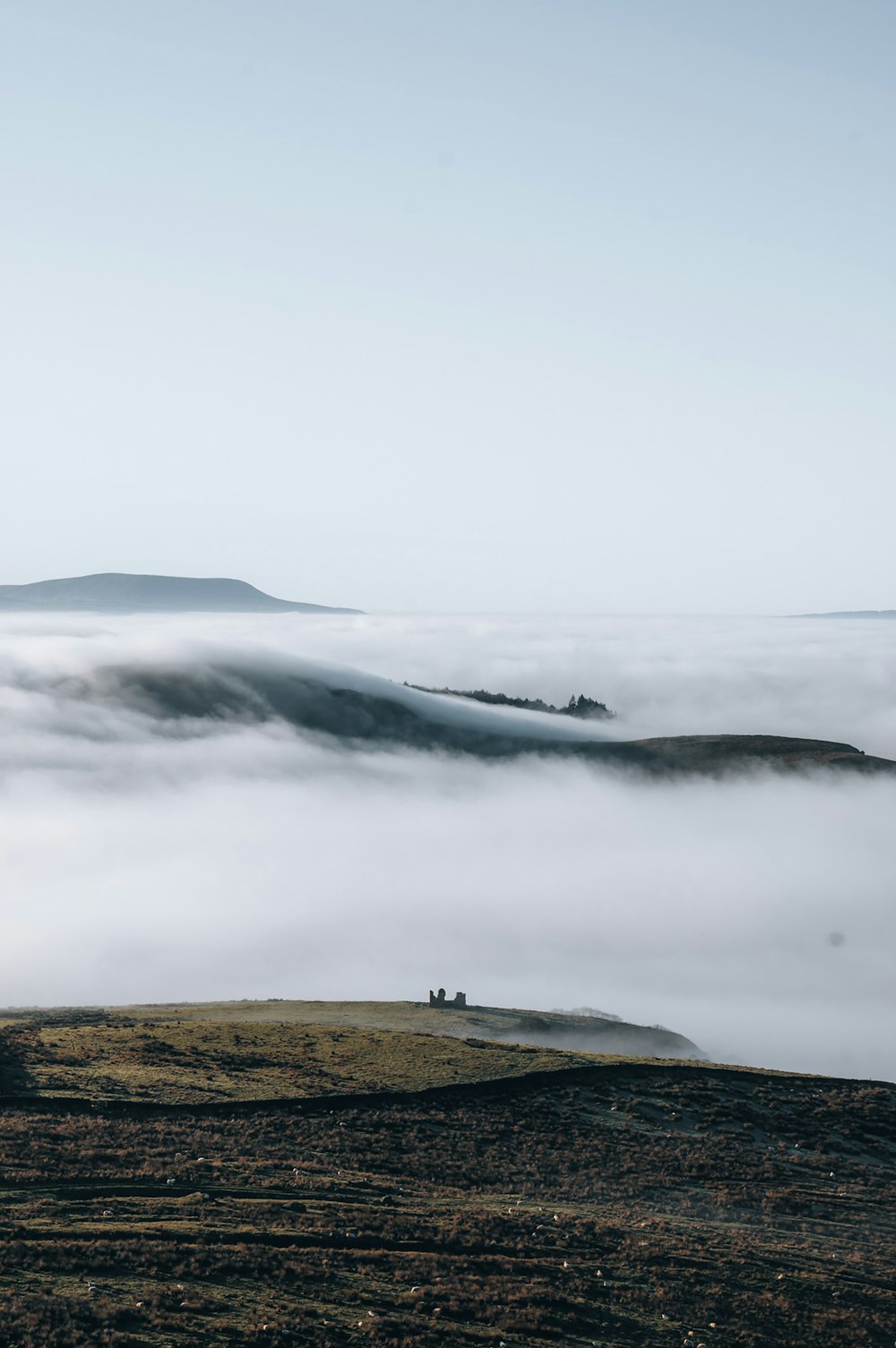 a hill covered in fog and low lying clouds