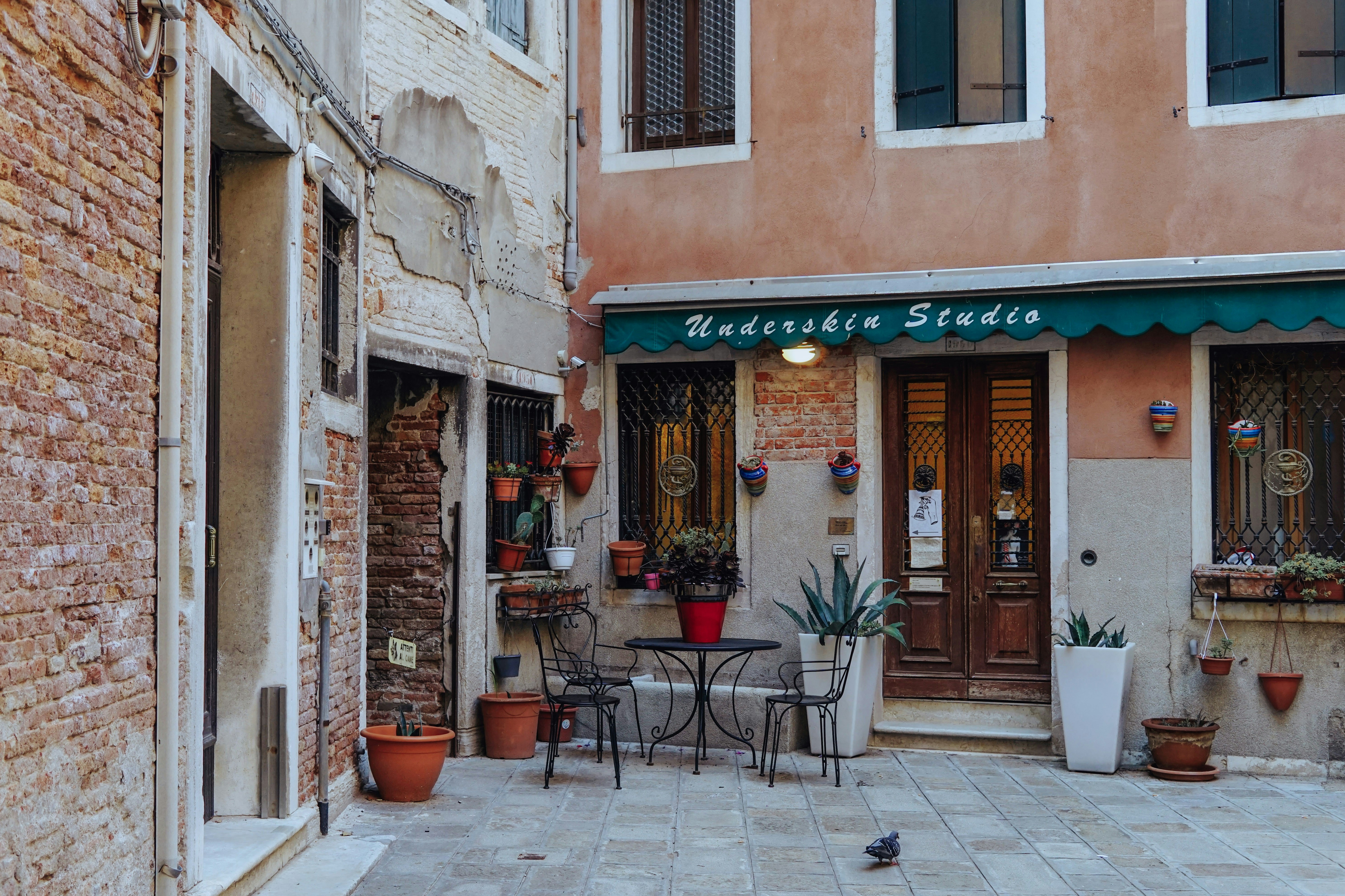 a small courtyard with tables and chairs in front of a building