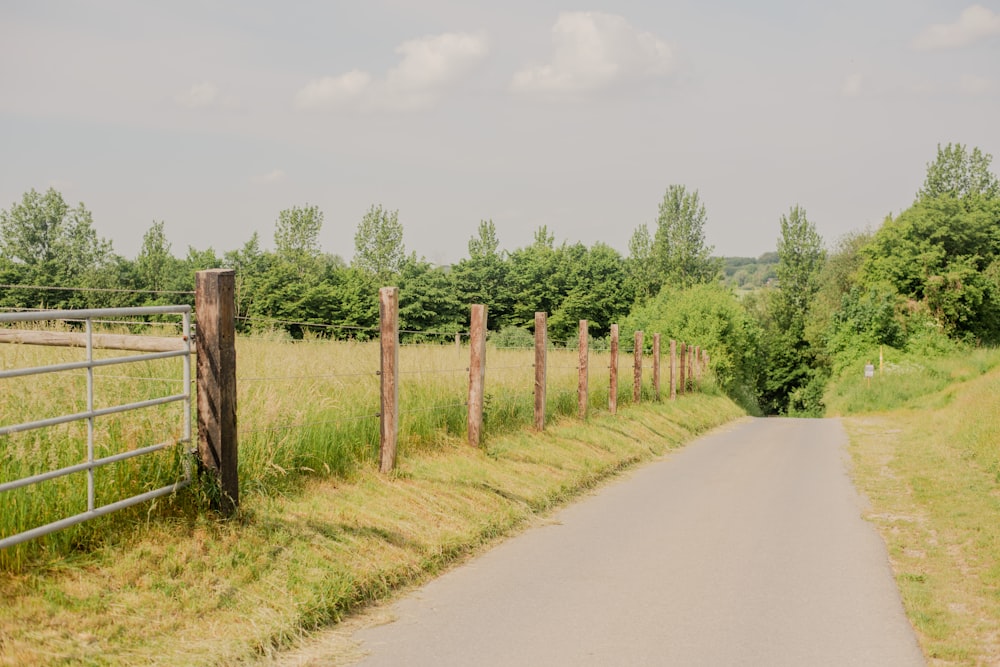 a road with a fence and a field behind it