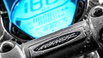 Close-up of a high-tech electric motorbike dashboard glowing with electric blue accents.