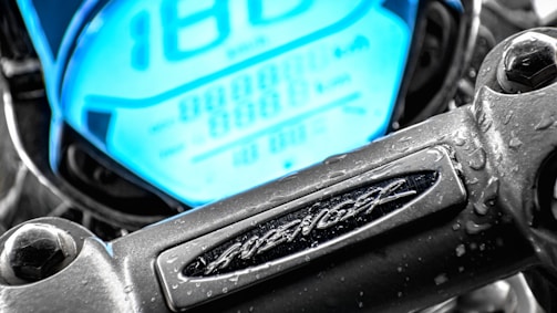 Close-up of the electric motorcycle's illuminated dashboard with futuristic digital displays glowing in blue.
