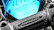 A close-up shot of a sleek motorcycle dashboard illuminated in neon blue against a dark background.